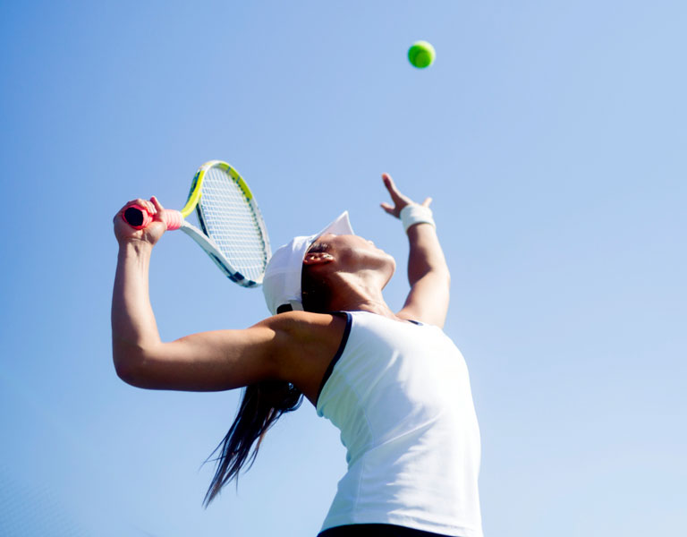 Photo of a female tennis player serving