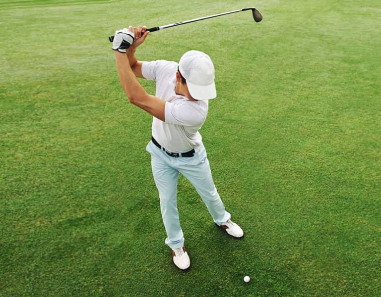 Photo of a male golfer taking a swing